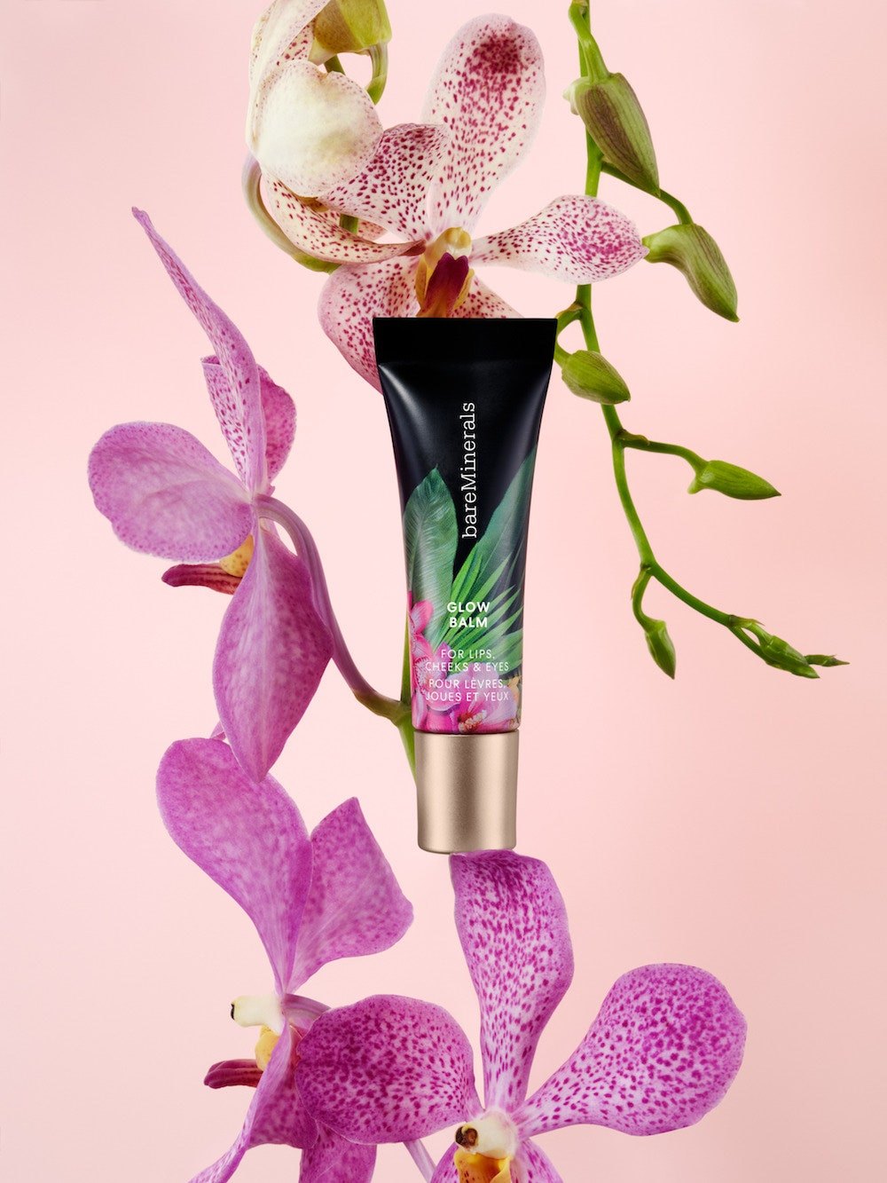 Glow Balm tube in the print among pink orchids