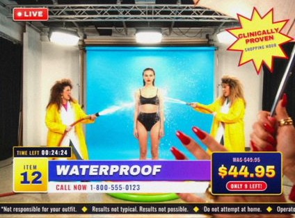 Style frame, item 12, Waterproof: assistants in yellow raincoats hose down a model on a blue set