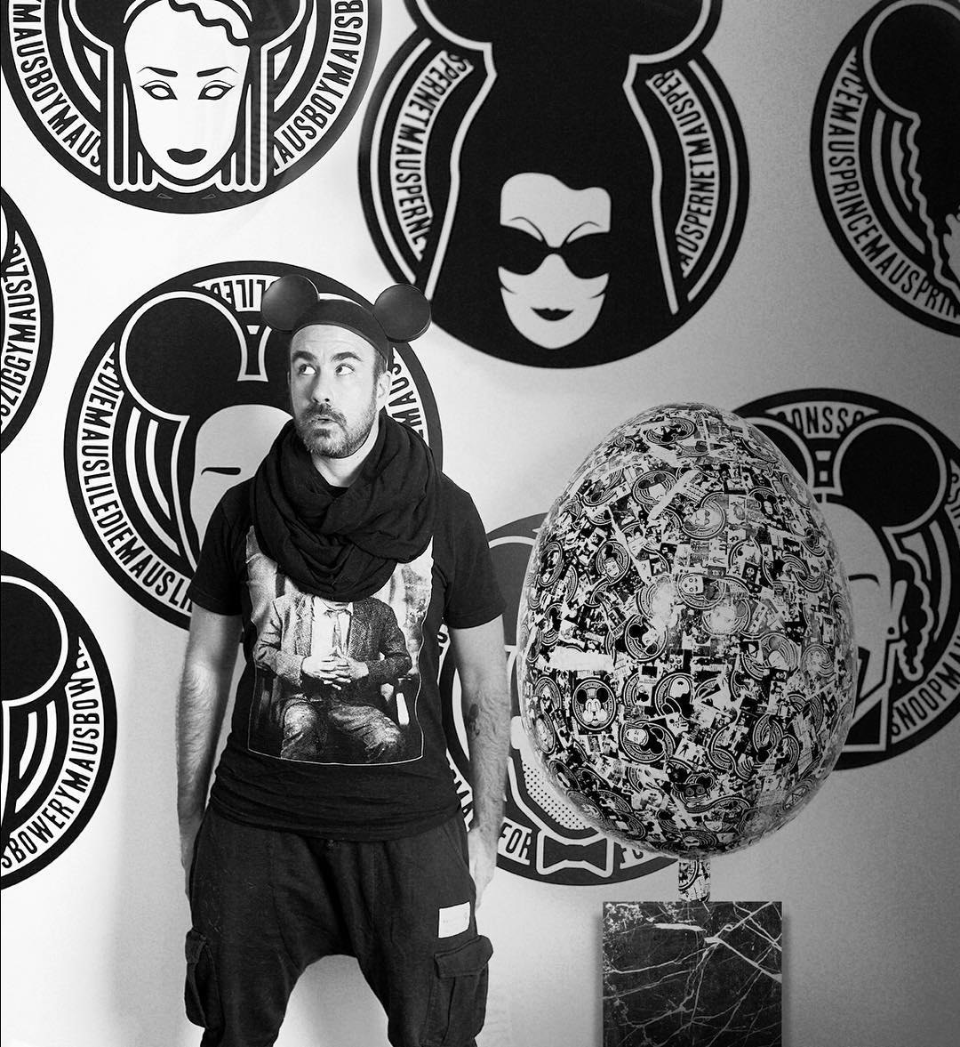 Christopher Lee Sauvé with the finished egg in front of a wall of MadMaus prints