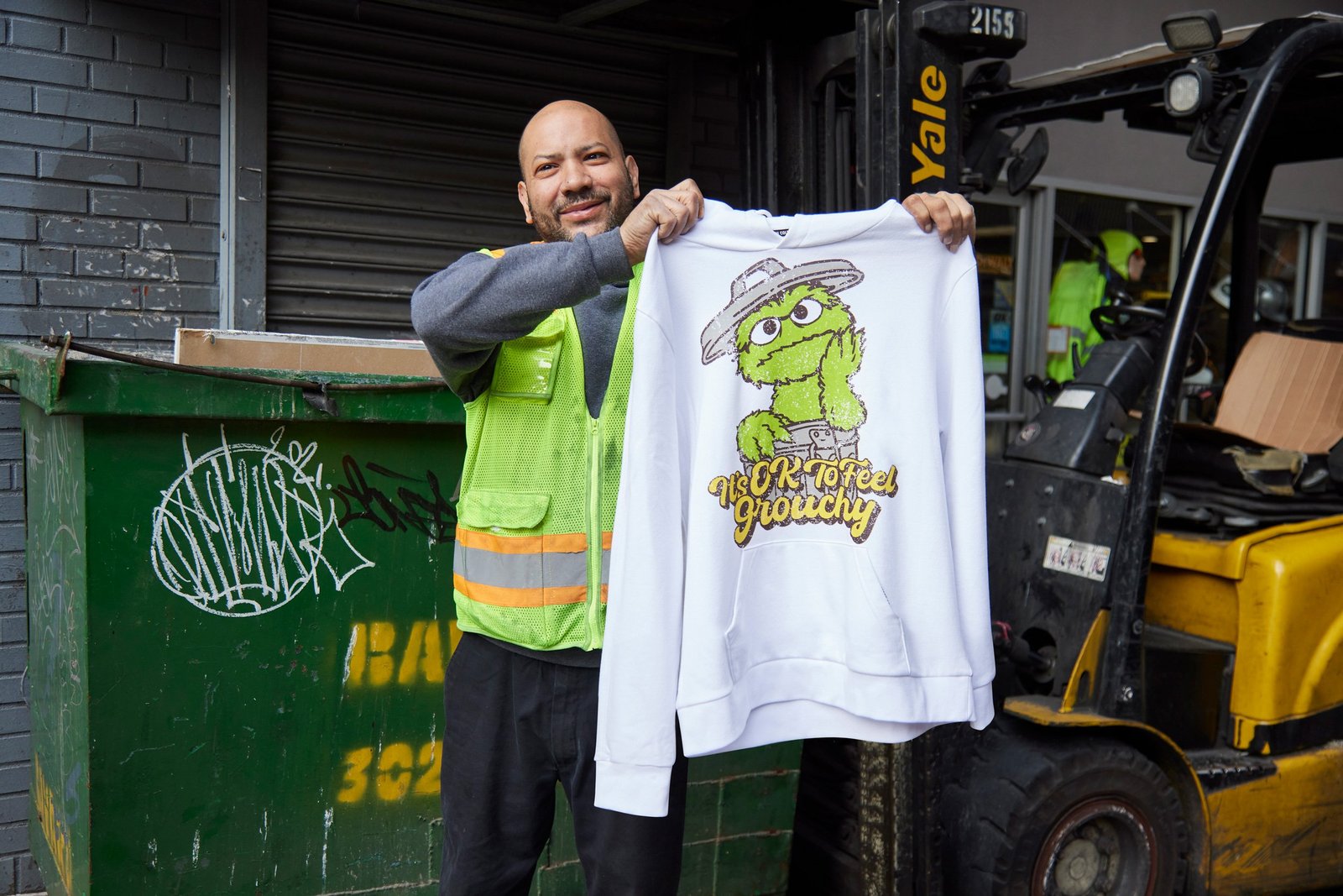 Sanitation worker holding up the Oscar hoodie