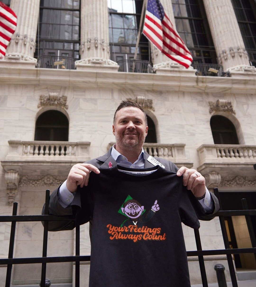 A man outside the New York Stock Exchange holding up the Count tee