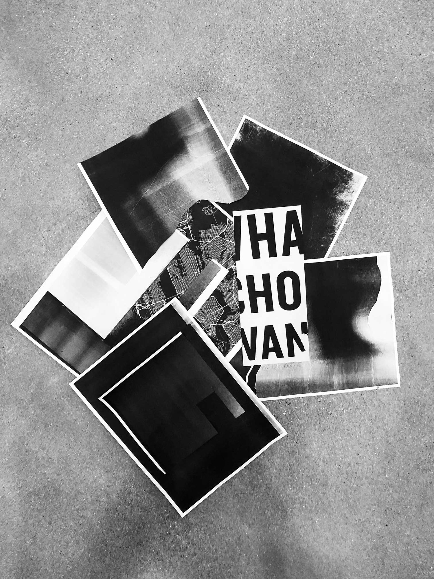Copies spread on a concrete floor: copier grain, a city map and big black type