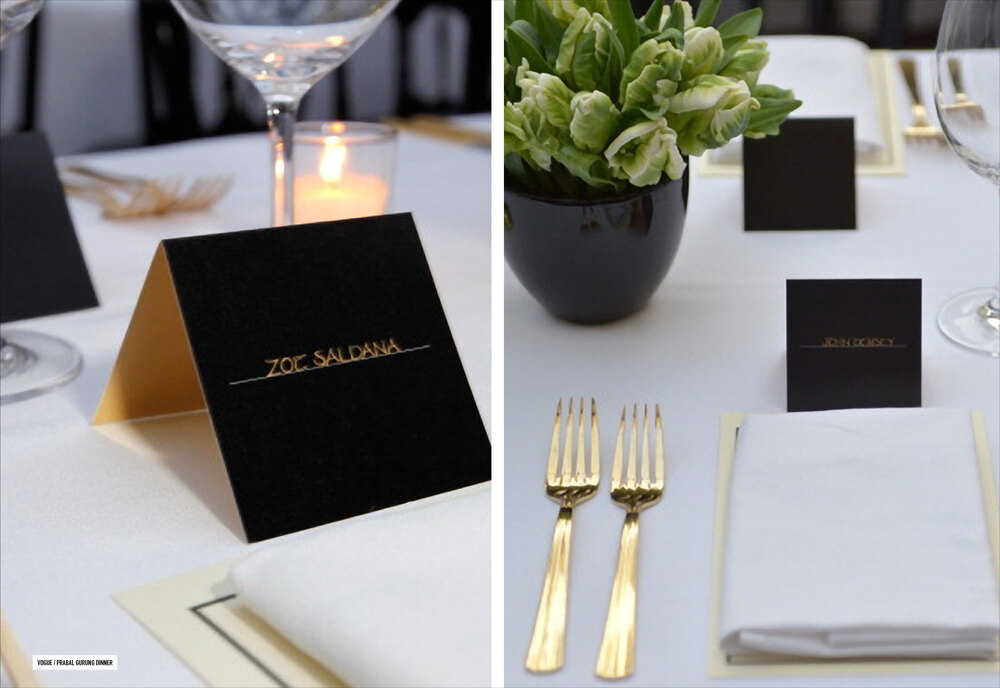 Black place cards with gold names and gold cutlery on the dinner table