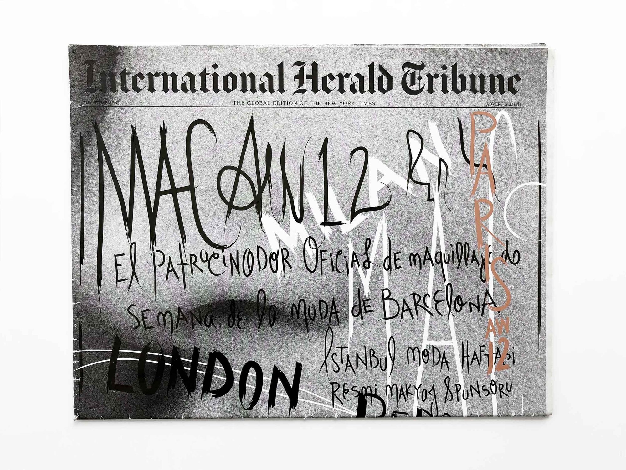 International Herald Tribune wrapped in AW12 lettering: MAC AW12, Milan, Paris and London, with the Barcelona Fashion Week sponsor line in Spanish