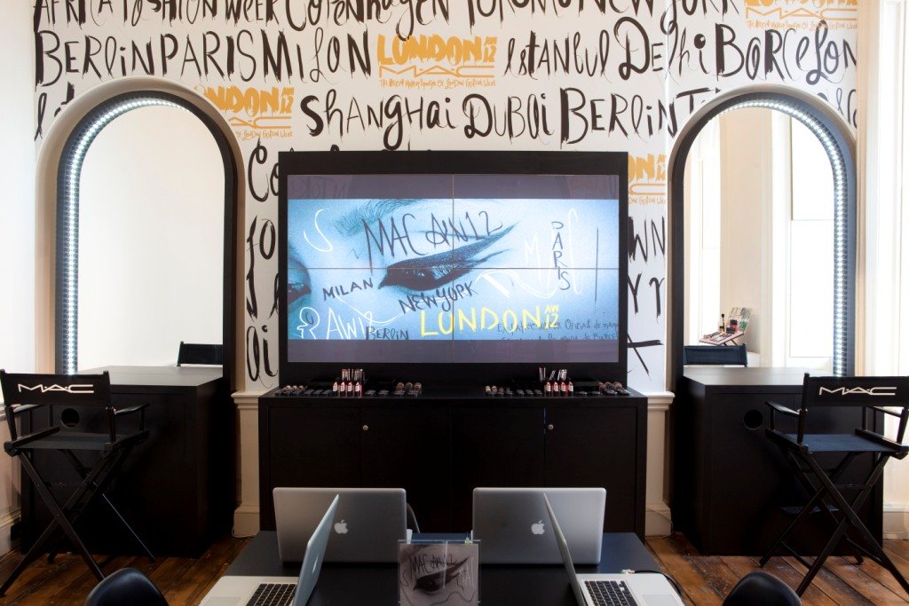 The M·A·C space at Selfridges London under a wall of hand-lettered city names