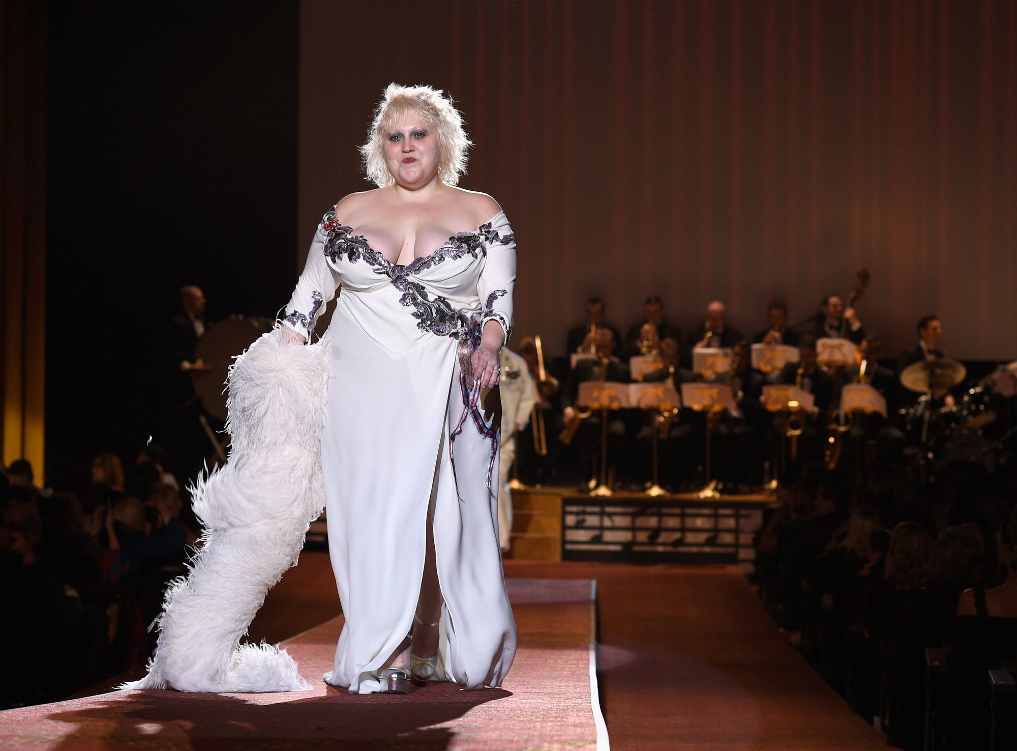 A model in white feathers on the runway at the Ziegfeld