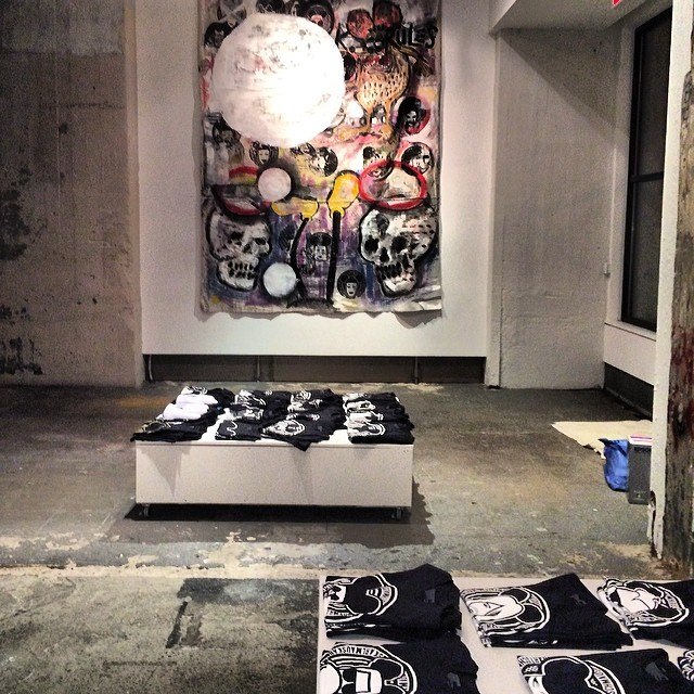 The hand-painted tees laid out in the gallery