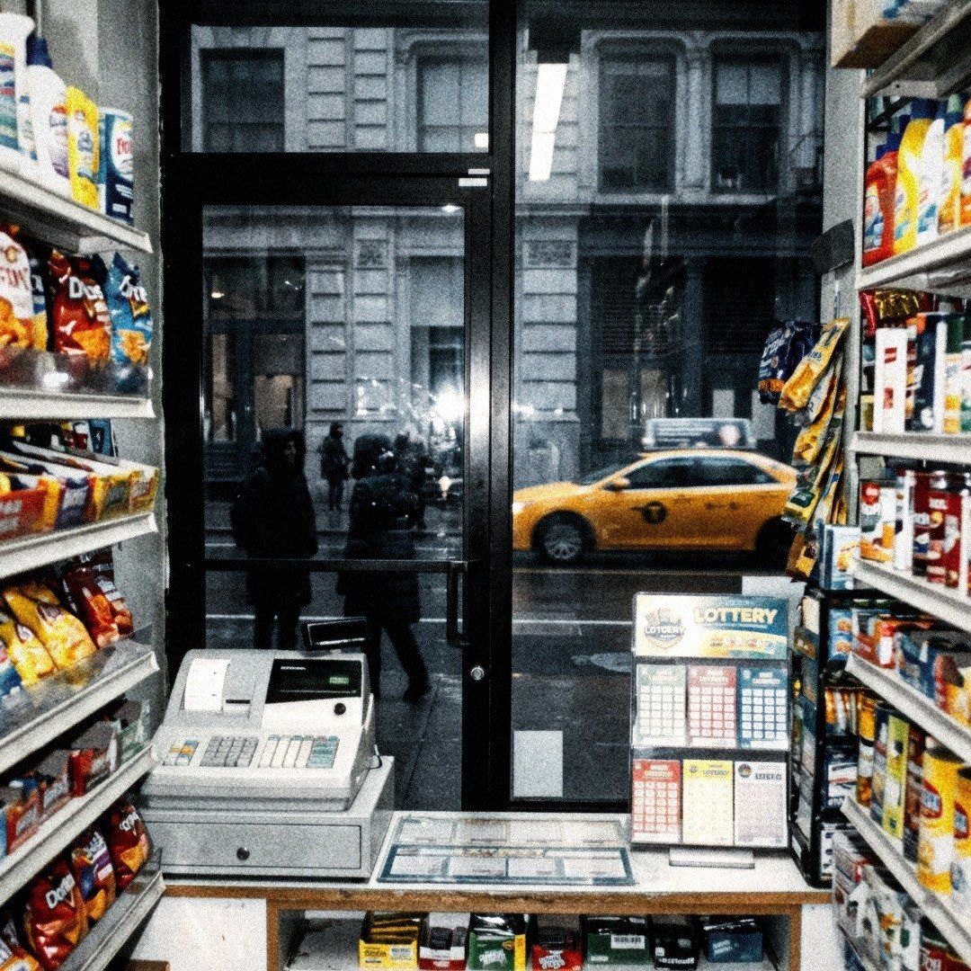 A corner bodega counter, a taxi outside