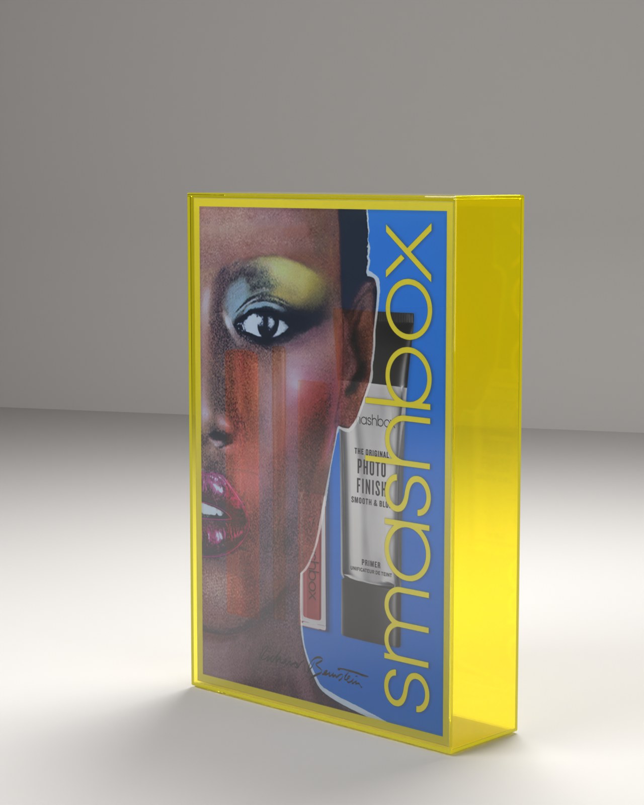 A rendered kit box in see-through neon yellow acrylic, Richard Bernstein’s signed portrait of Grace Jones on the front with the smashbox wordmark in yellow on blue