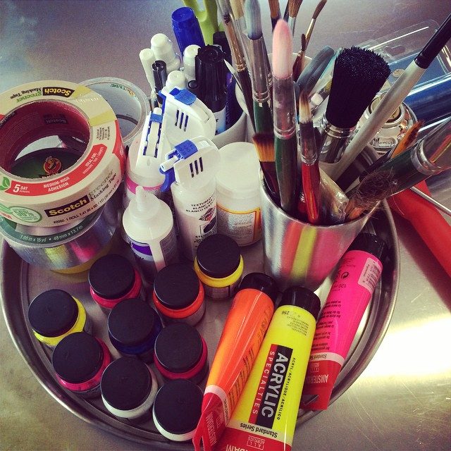 Paint pots, markers and brushes on the desk