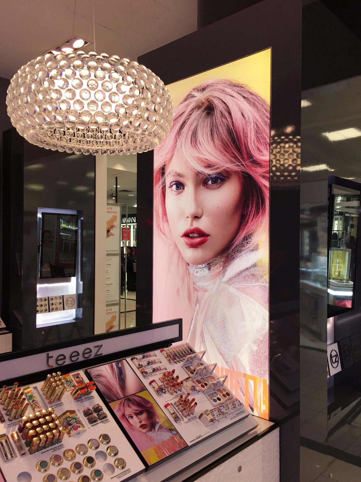 The Fashion Vendetta portrait on a backlit column above the Teeez palette wall
