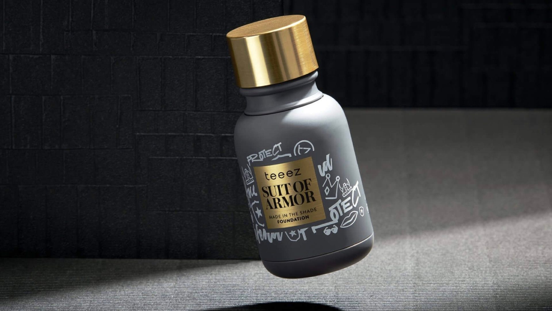 Suit of Armor foundation bottle in charcoal and gold