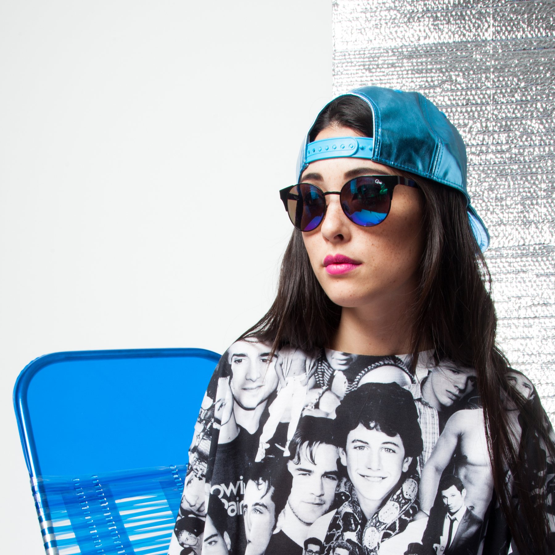 Model in a teal cap and mirrored sunglasses