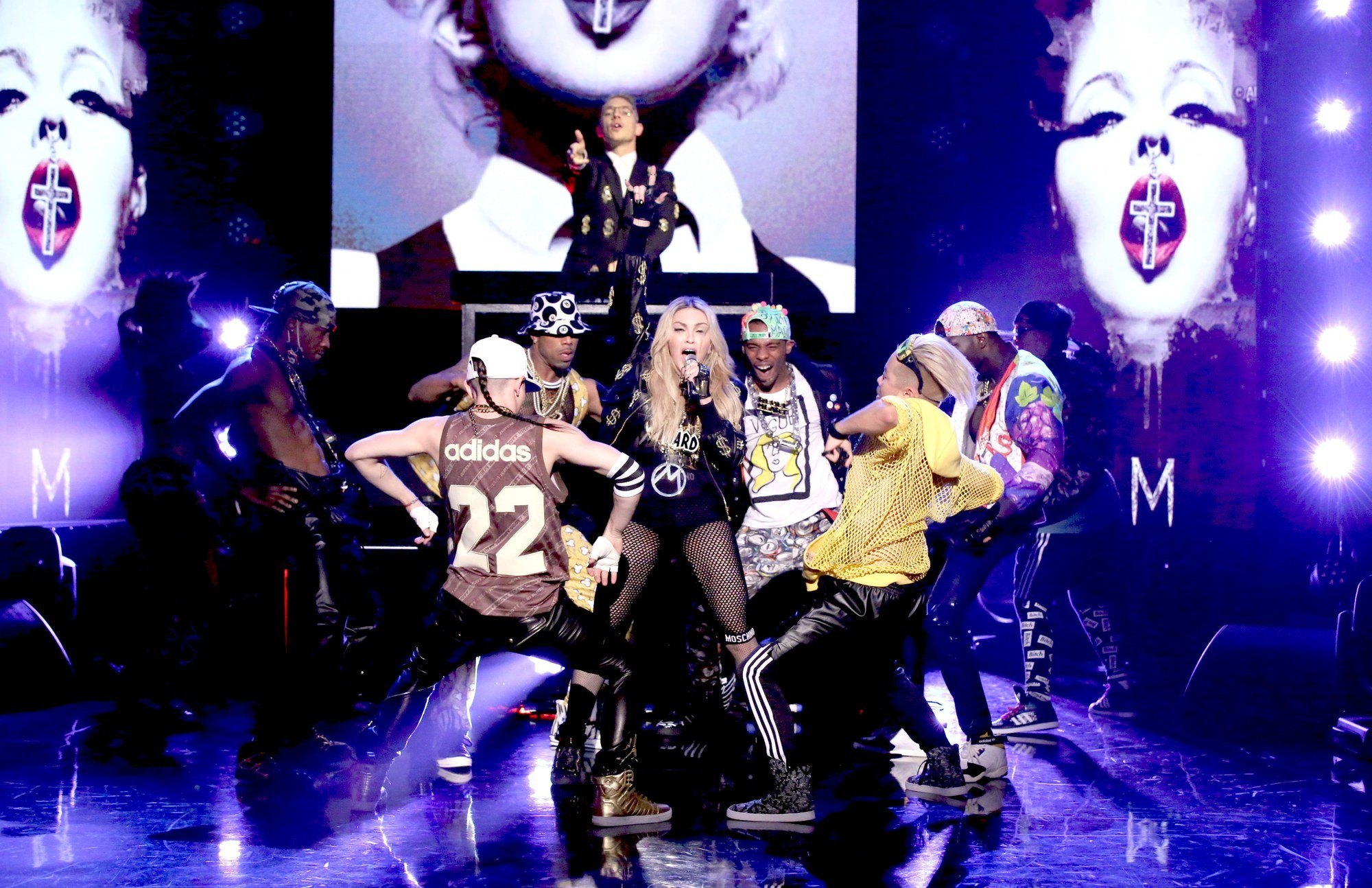 Madonna on stage with dancers wearing hand painted tees and boots