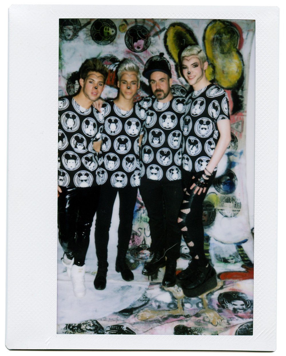 Polaroid of the MadMaus crew against a wall of art