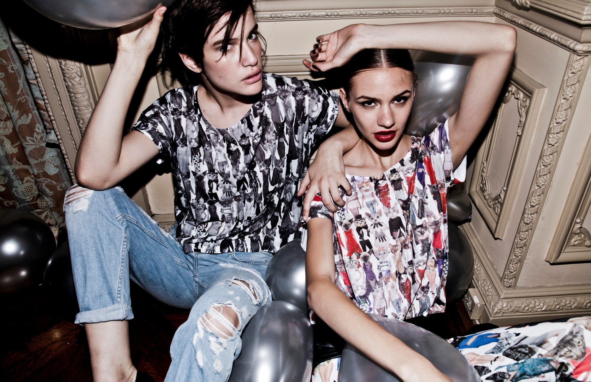 Two models in print tees among silver balloons