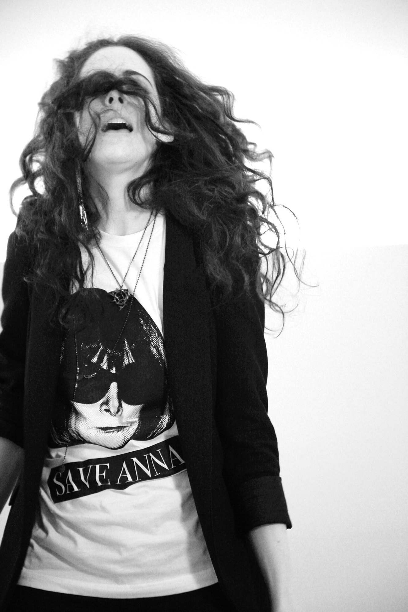 Model laughing in a black blazer over the Save Anna tee