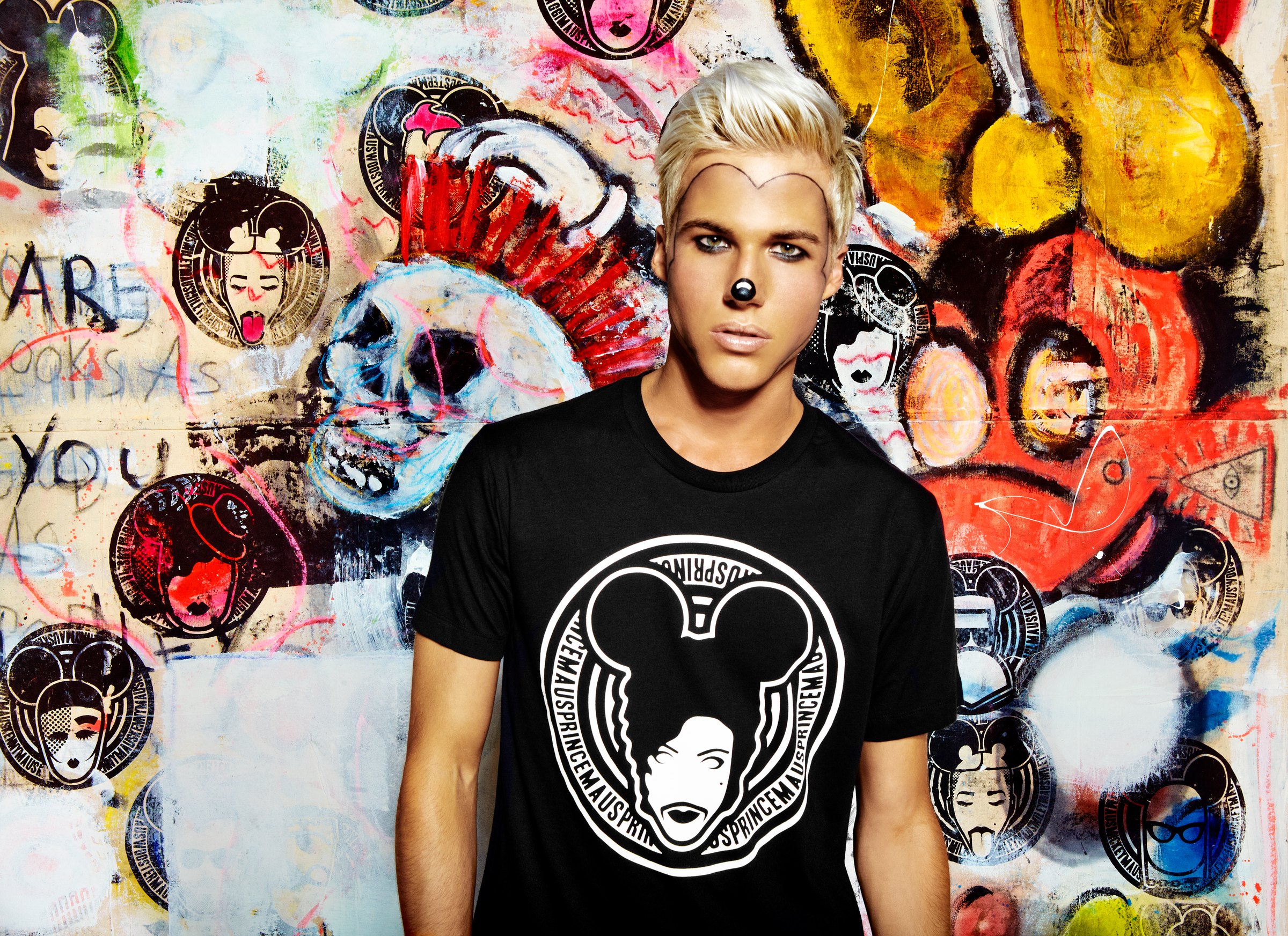 Model with a painted mouse nose in a black MadMaus seal tee, in front of a painted wall of mice and seals