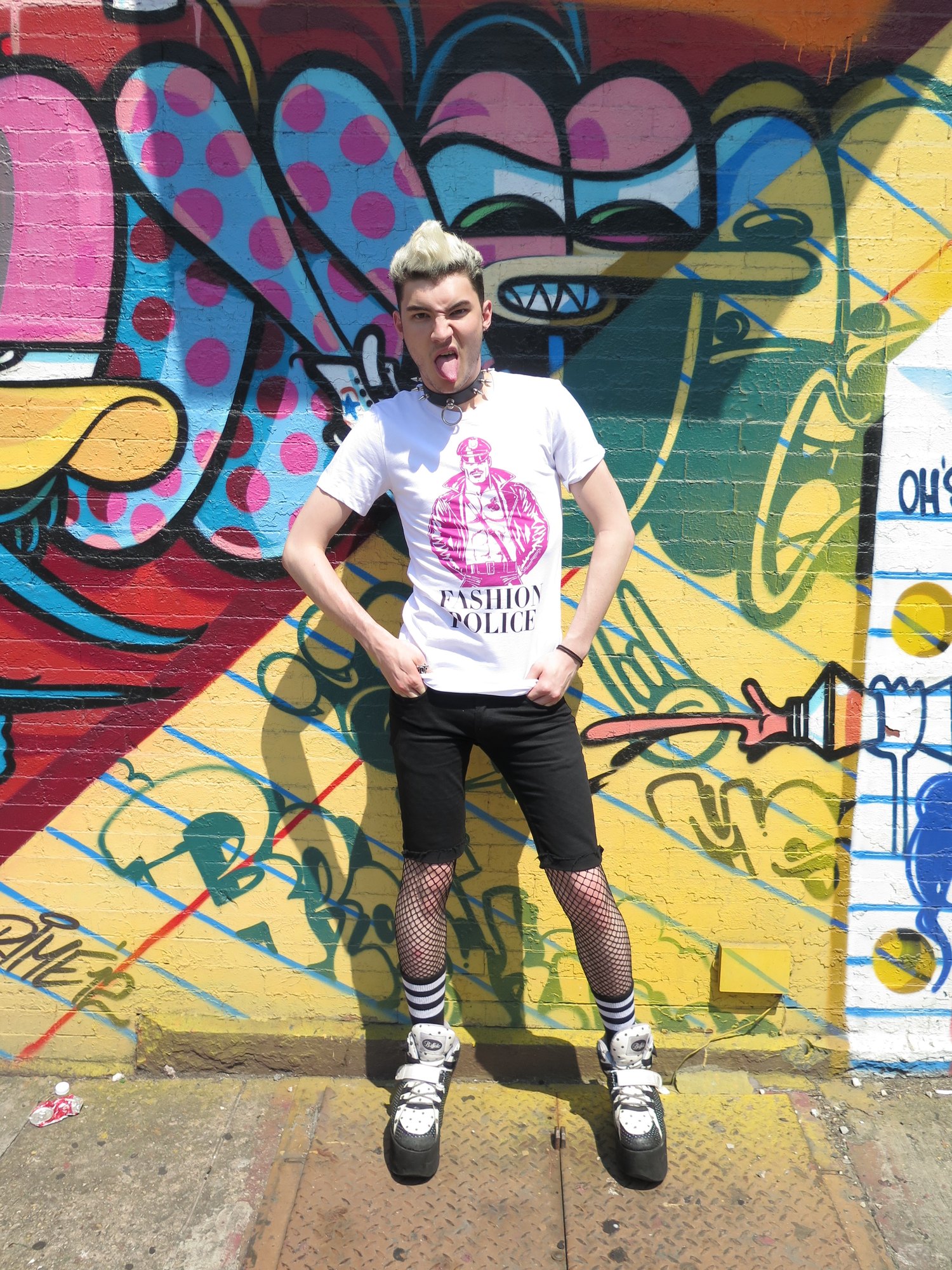 Model in the Fashion Police tee against a graffiti wall
