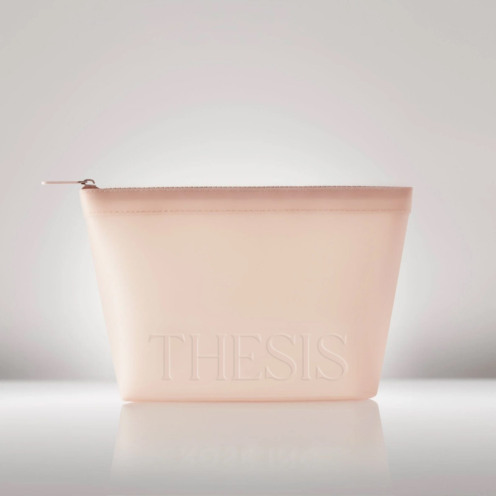 A pink pouch with THESIS debossed